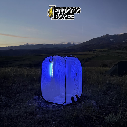 EntomoBoxes moth light trap glowing blue at dusk with snow-capped mountains in the background